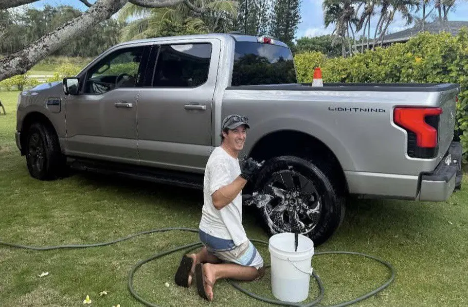 Jess Kraus, owner of Mantra Auto Detailing, detailing wheels on a Ford F-150 Lightning on the North Shore